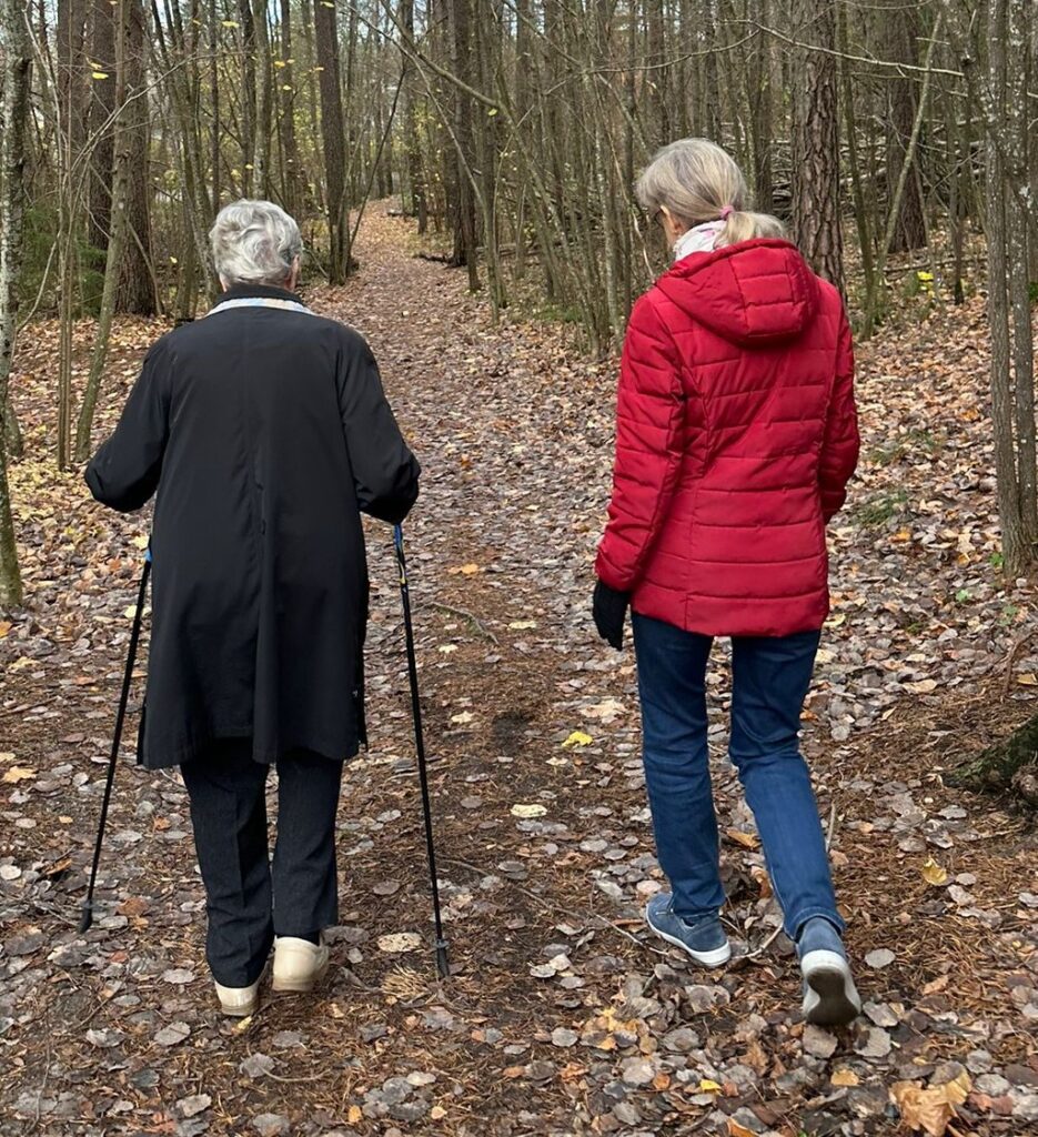 Vapaaehtoinen ja ikäihminen ulkoilemassa